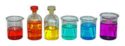 From left to right, aqueous solutions of: Co(NO3)2 (red); K2Cr2O7 (orange); K2CrO4 (yellow); NiCl2 (green); CuSO4 (blue); KMnO4 (purple).