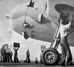 As a TBF Avenger prepares to take off from Enterprise on October 26, the signs held aloft by deck crewmen give the last known location of the Japanese carriers as well as instructions to proceed without waiting for Hornet&rsquo;s aircraft.