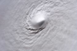 A picture of Hurricane Wilma's eye taken at 08:22 CDT (13:22 UTC) October 19, 2005, by the crew aboard the International Space Station. At the time, Wilma was the strongest Atlantic hurricane in history, with a minimum central pressure of only 882&nbsp;mbar (26.06&nbsp;inHg). Not only is this a classic example of a pinhole eye, but also of the stadium effect, where the eyewall slopes out and up.