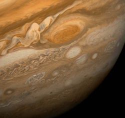 This dramatic view of Jupiter's Great Red Spot and its surroundings was obtained by Voyager 1 on February 25, 1979, when the spacecraft was 9.2&nbsp;million&nbsp;km (5.7&nbsp;million&nbsp;mi) from Jupiter. Cloud details as small as 160&nbsp;km (100&nbsp;mi) across can be seen here. The colorful, wavy cloud pattern to the left of the Red Spot is a region of extraordinarily complex and variable wave motion. To give a sense of Jupiter's scale, the white oval storm directly below the Great Red Spot is approximately the same diameter as Earth.