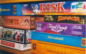 A shelf with several currently available board games. The left stack contains Carcassonne, La Citt&agrave;, Party & Co, and Monopoly. The right stack contains Risk, Drakon, Trivial Pursuit, The Seafarers of Catan, and Cities and Knights of Catan; some are of Dutch editions.