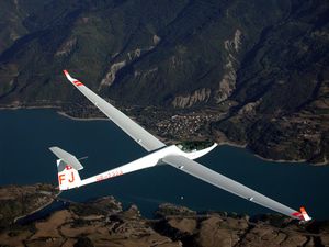 A single-seat high performance fiberglass Glaser-Dirks DG-808 over the Lac de Serre Pon&ccedil;on in the French Alps