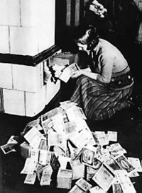 Inflation 1923&ndash;24: a woman feeds her tiled stove with money. At the time, burning money was less expensive than buying firewood.