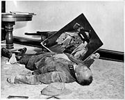 With a torn picture of his F&uuml;hrer beside his clenched fist, a dead general of the Volkssturm lies on the floor of city hall, Leipzig, Germany. He committed suicide rather than face U.S. Army troops who captured the city.