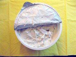 Open package of cream cheese with chives, a soy milk based cream cheese alternative