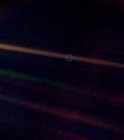 A photo of Earth (circled) taken by Voyager 1, 6.4 billion km (4 billion miles) away. The streaks of light are diffraction spikes radiating from the Sun (off frame to the left). This photograph is known as "Pale Blue Dot".