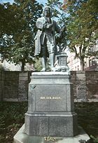 Since being moved in 1938, the Donndorf statue of Bach now stands in the Frauenplan in Eisenach. The pedestal has been shortened and the relief now is at the wall in the background.