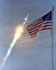 A condensation cloud is seen sticking to the Apollo 11 Saturn V launch vehicle as it works its way up through the dense, lower atmosphere. See: Max Q.